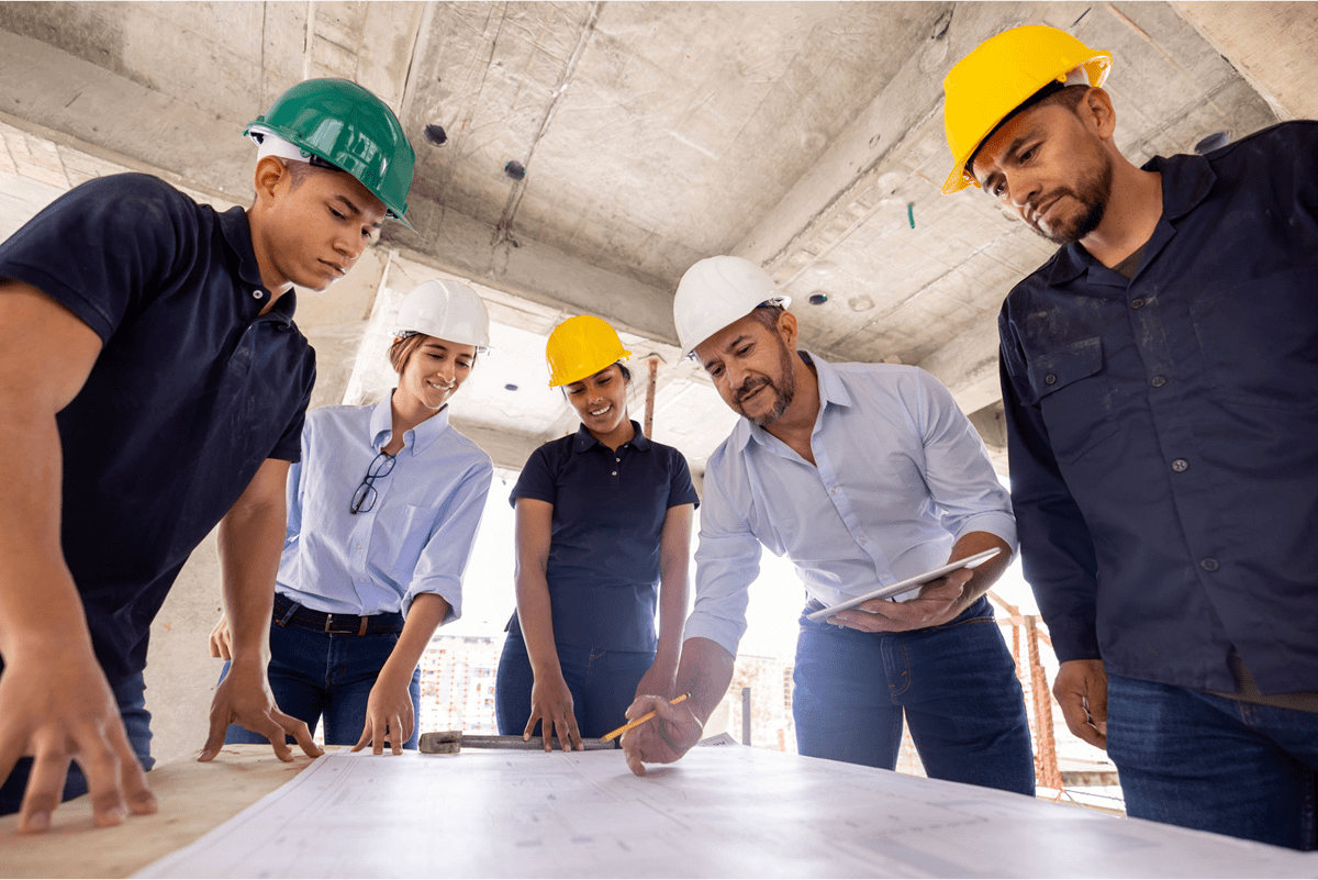 Construction team reviewing blueprints on site.