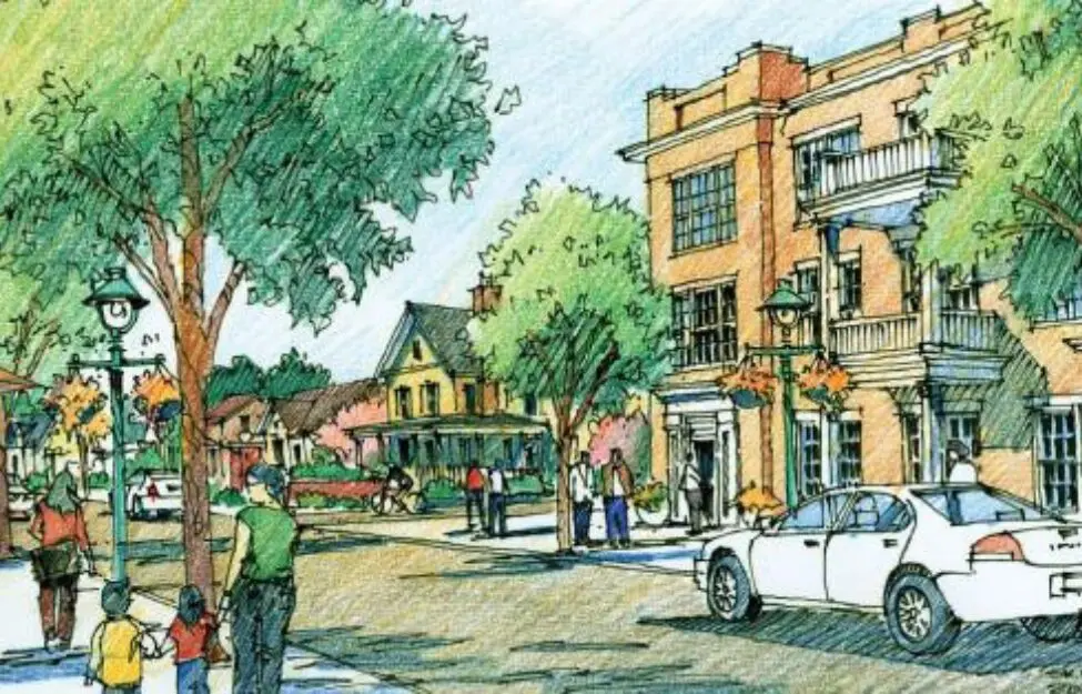 A lively street scene with buildings, trees, and people enjoying the day.