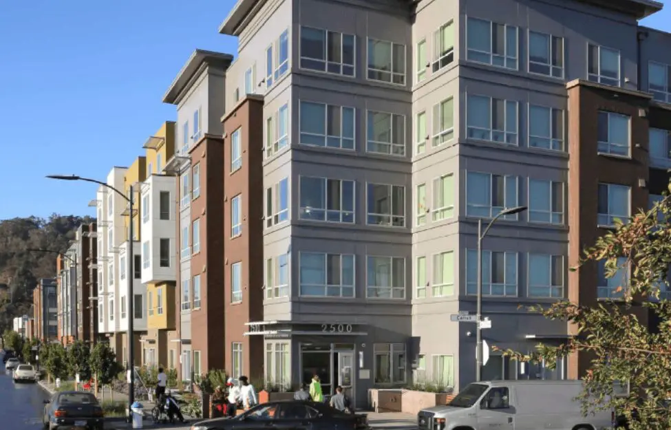 Modern multi-story residential building on a sunny day.